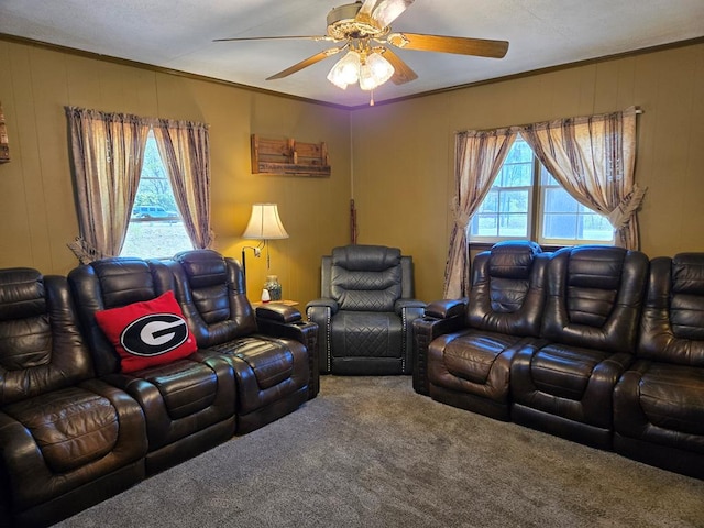 carpeted living area with ceiling fan and crown molding