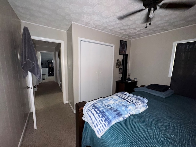 carpeted bedroom featuring ceiling fan and a textured ceiling