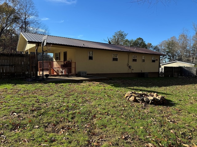 rear view of property featuring a lawn and a patio area