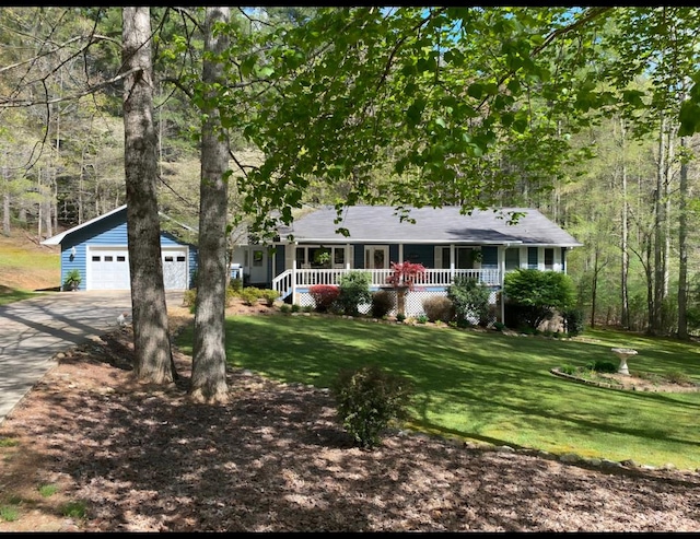 single story home with a garage, an outdoor structure, a front yard, and covered porch