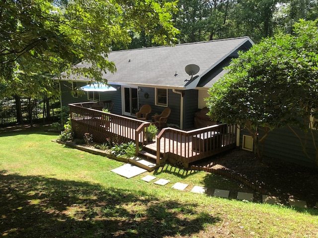 back of house with a deck and a lawn