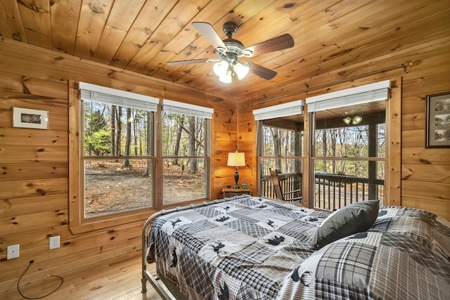 bedroom with wood ceiling, ceiling fan, and wooden walls