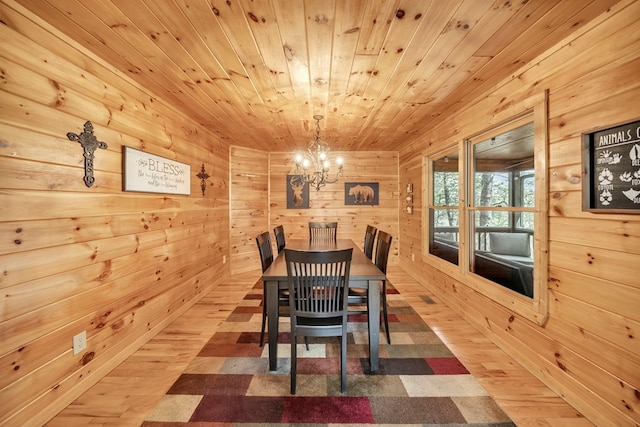 dining space featuring wooden ceiling, light hardwood / wood-style flooring, wooden walls, and an inviting chandelier