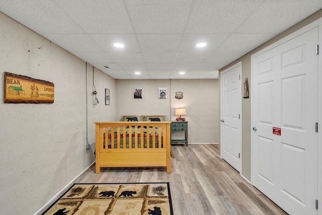 bedroom featuring light hardwood / wood-style floors and a paneled ceiling