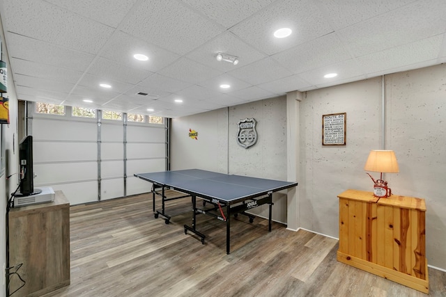 game room with light hardwood / wood-style flooring and a paneled ceiling