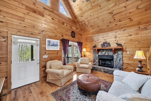 living room with high vaulted ceiling, a fireplace, light hardwood / wood-style flooring, wooden ceiling, and a skylight