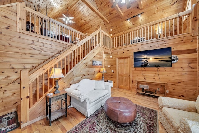 living room featuring wood ceiling, light hardwood / wood-style flooring, and high vaulted ceiling