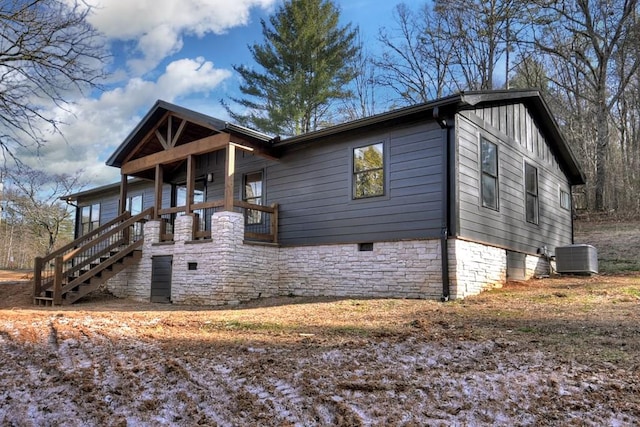 view of front of property featuring stairs, central AC unit, and board and batten siding