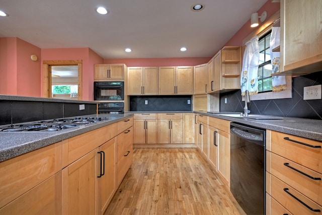 kitchen with black appliances, a healthy amount of sunlight, light wood finished floors, and light brown cabinetry