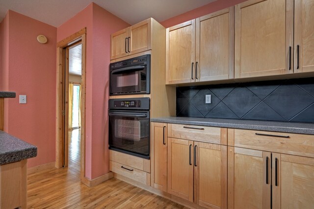 kitchen featuring light hardwood / wood-style flooring, light brown cabinets, sink, black appliances, and decorative backsplash