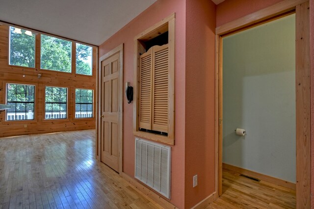 kitchen with light hardwood / wood-style flooring, appliances with stainless steel finishes, lofted ceiling, and a healthy amount of sunlight