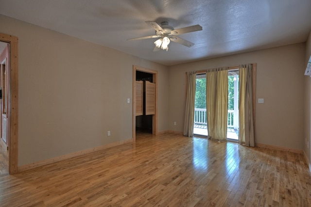 unfurnished room featuring a ceiling fan, wood finished floors, and baseboards