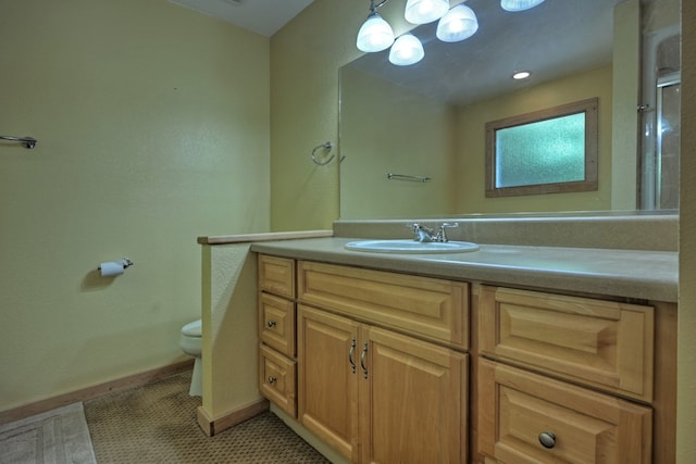 bathroom with baseboards, toilet, and vanity