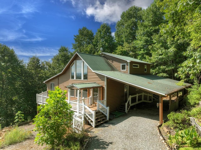 cabin featuring covered porch and a carport