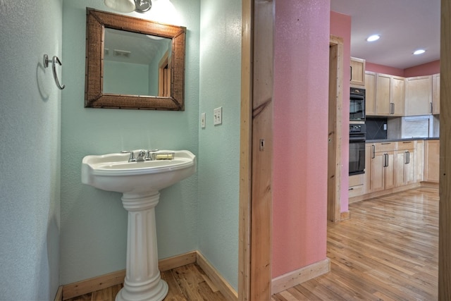 bathroom with recessed lighting, baseboards, and wood finished floors