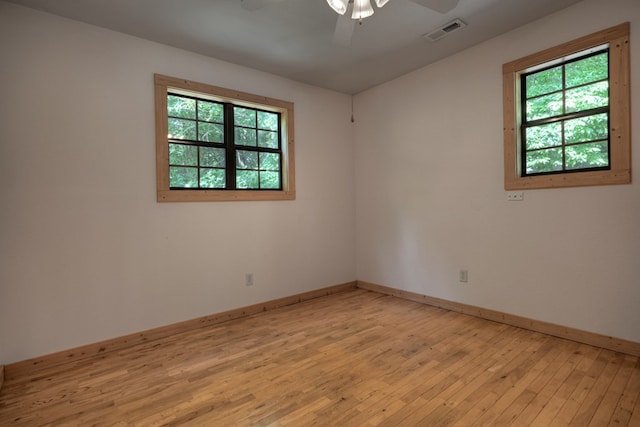 unfurnished room with baseboards, a ceiling fan, visible vents, and light wood-type flooring