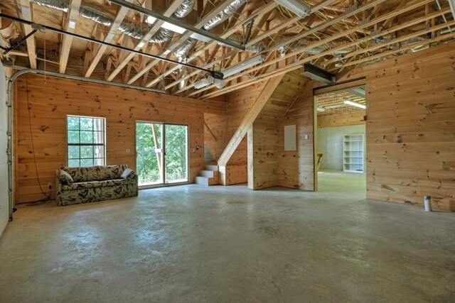 garage featuring electric panel, a garage door opener, and wooden walls