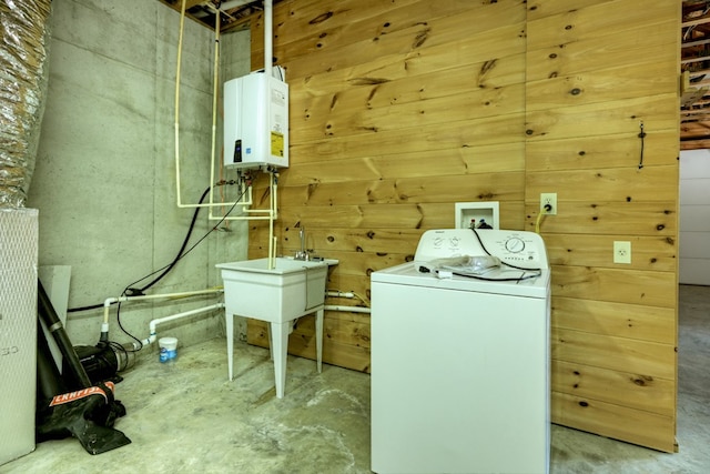 clothes washing area featuring tankless water heater, laundry area, washer / clothes dryer, and wooden walls