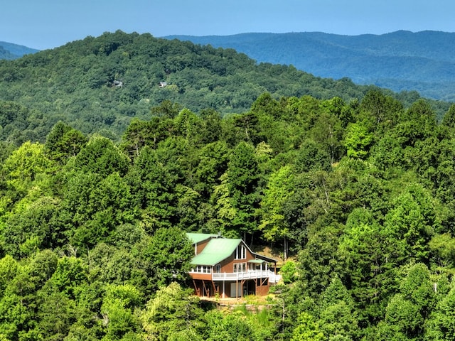 birds eye view of property with a mountain view and a wooded view