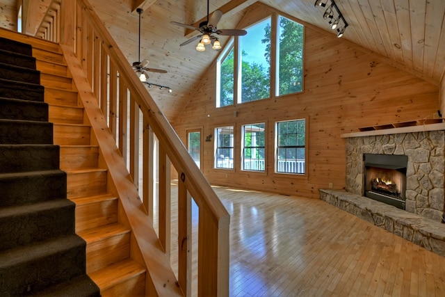 interior space with hardwood / wood-style flooring, wooden walls, wooden ceiling, and ceiling fan