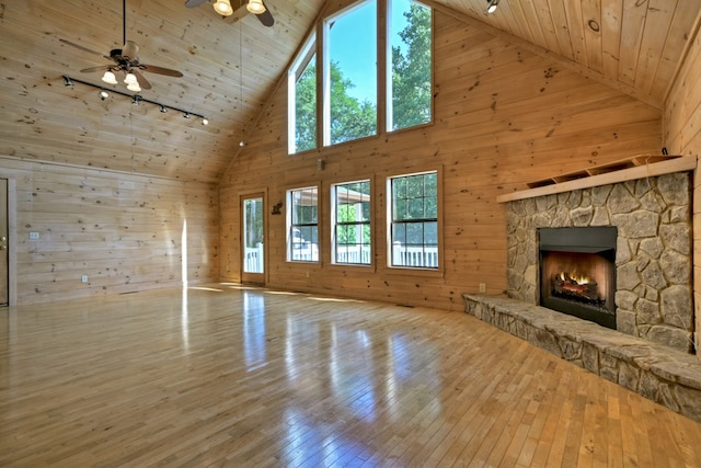 unfurnished living room featuring ceiling fan, wood walls, wood ceiling, hardwood / wood-style floors, and rail lighting