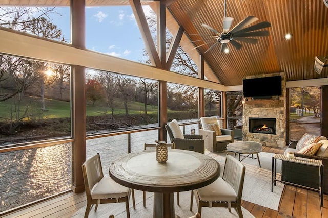 sunroom / solarium featuring lofted ceiling, a fireplace, and ceiling fan