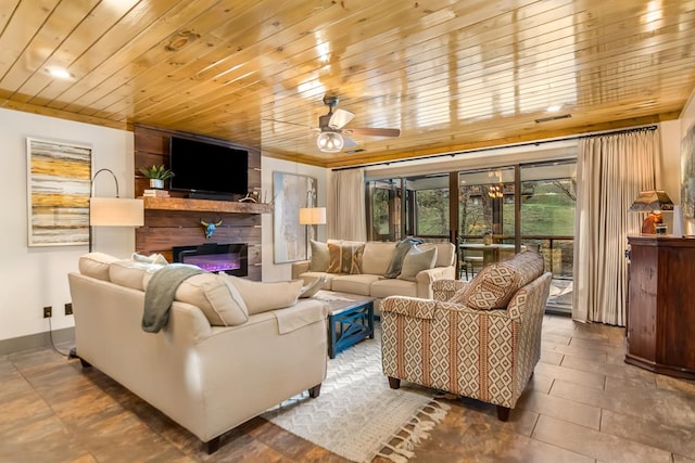 living room featuring visible vents, a ceiling fan, a glass covered fireplace, baseboards, and wood ceiling