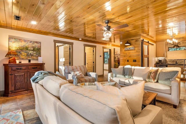 living room featuring visible vents, a barn door, ornamental molding, ceiling fan with notable chandelier, and wooden ceiling