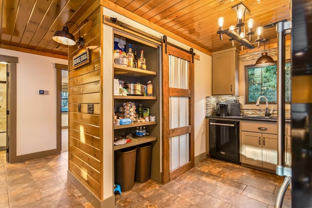 kitchen featuring dark countertops, a barn door, a sink, black dishwasher, and wooden ceiling