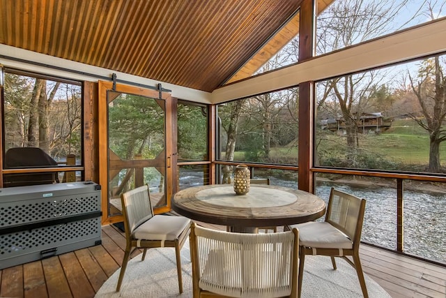 sunroom / solarium with lofted ceiling and a water view