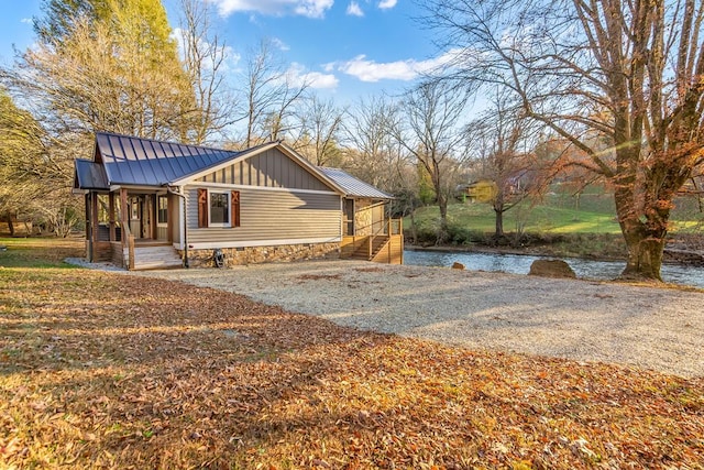 view of property exterior featuring driveway, metal roof, a standing seam roof, and board and batten siding