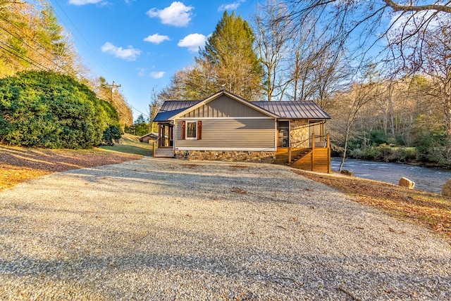 view of front of home with gravel driveway, a standing seam roof, and metal roof