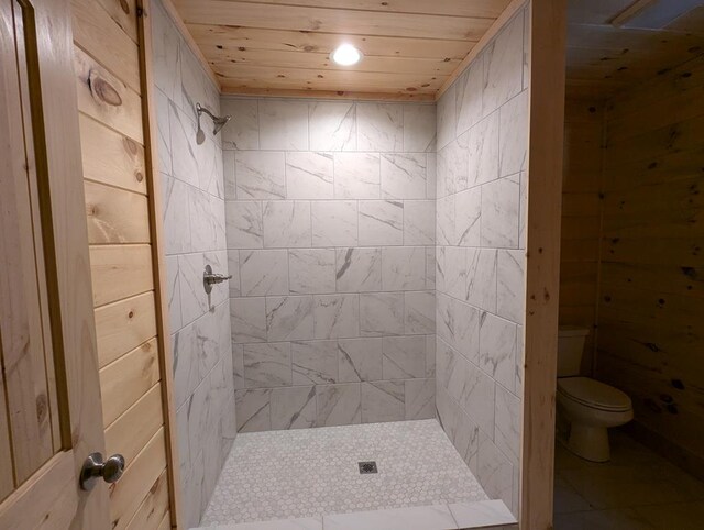 bathroom featuring wood ceiling, toilet, and a tile shower