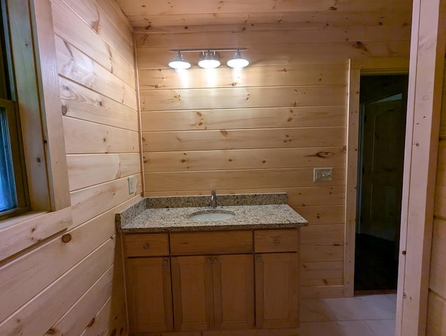 bathroom featuring vanity and wood walls