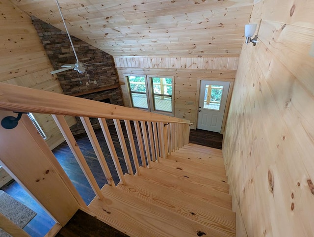 stairs featuring wood-type flooring, wooden walls, vaulted ceiling, and wooden ceiling