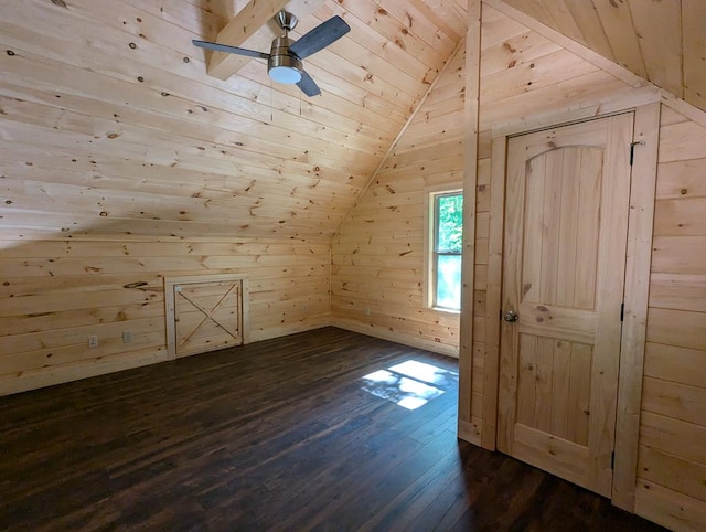 bonus room featuring dark wood-type flooring, wood walls, vaulted ceiling, wooden ceiling, and ceiling fan