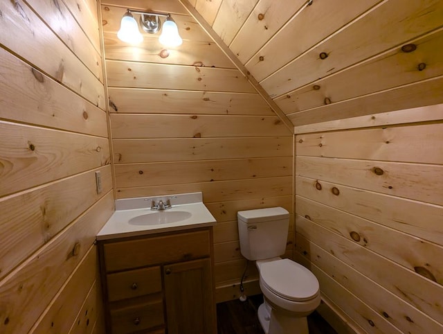 bathroom with vanity, toilet, wooden ceiling, and wood walls