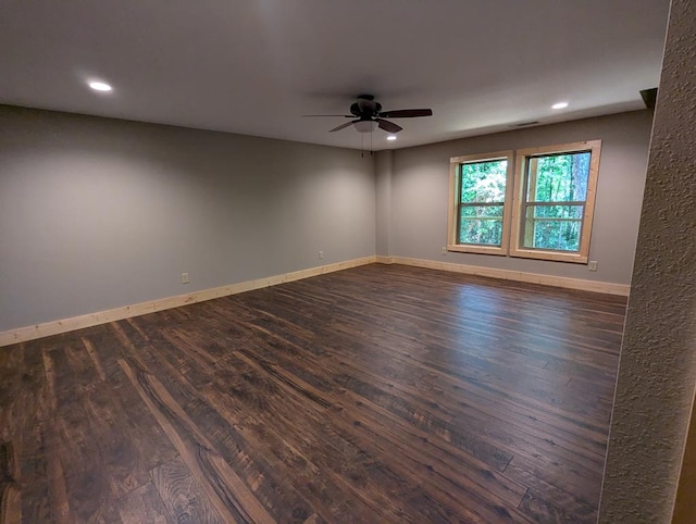 empty room with dark hardwood / wood-style flooring and ceiling fan