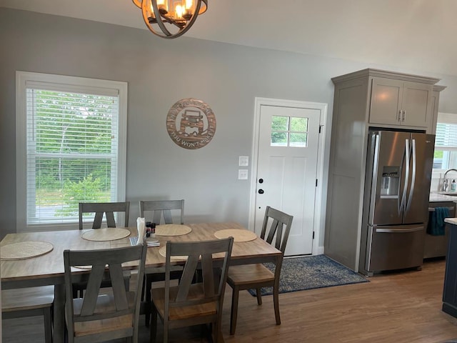 dining space featuring hardwood / wood-style floors, a wealth of natural light, and a chandelier