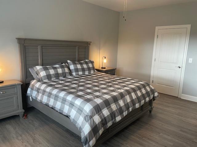 bedroom with dark hardwood / wood-style flooring