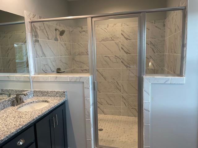 bathroom with vanity and a shower with door