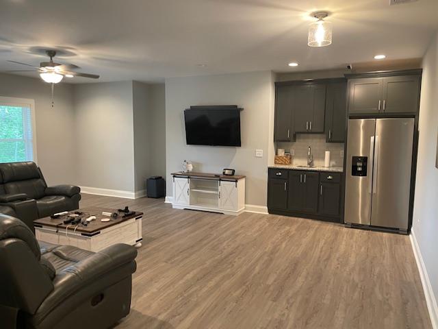 living room with ceiling fan, sink, and hardwood / wood-style floors