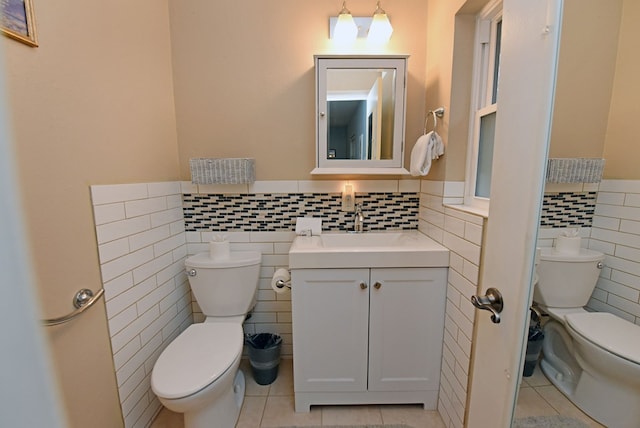 bathroom with tile patterned flooring, toilet, and tile walls