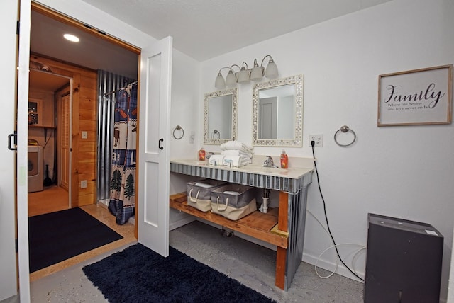 bathroom featuring vanity and washer / dryer