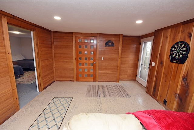 foyer featuring wooden walls and a textured ceiling