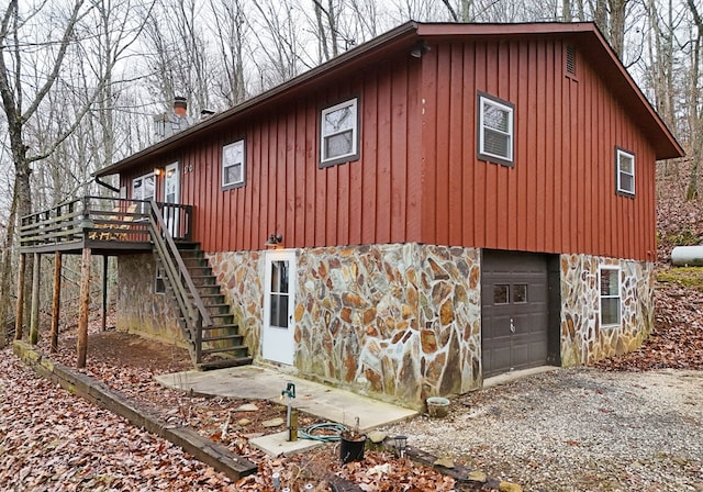 view of side of property featuring a garage and a deck