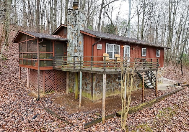 rear view of house featuring a sunroom and a wooden deck