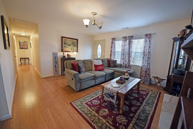 living room featuring a notable chandelier and light hardwood / wood-style floors