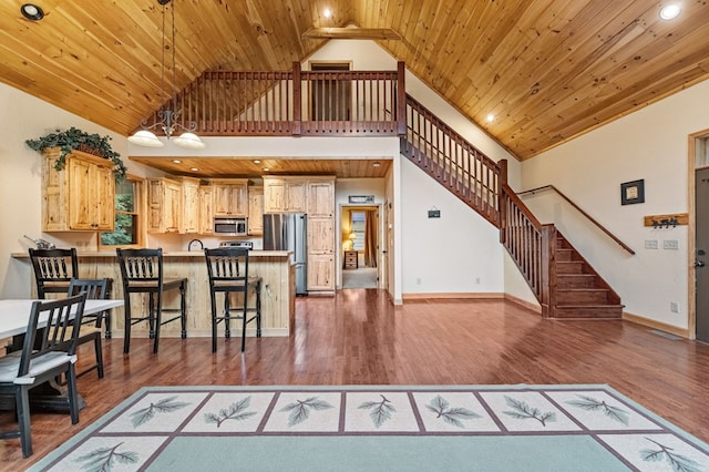 living room with wood ceiling, wood finished floors, baseboards, and stairs