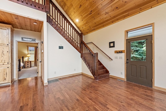 foyer featuring wooden ceiling, stairway, and wood finished floors